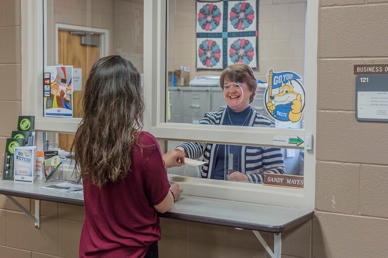woman paying her tution at a clerk window